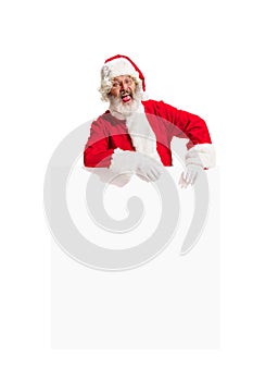 Happy Santa Claus pointing on blank advertisement banner background with copy space. Smiling Santa Claus pointing in