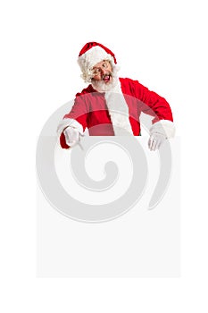 Happy Santa Claus pointing on blank advertisement banner background with copy space. Smiling Santa Claus pointing in