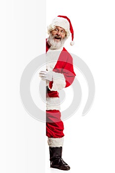 Happy Santa Claus pointing on blank advertisement banner background with copy space. Smiling Santa Claus pointing in