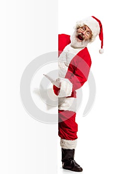 Happy Santa Claus pointing on blank advertisement banner background with copy space. Smiling Santa Claus pointing in