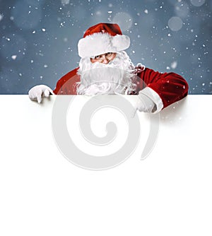 Happy Santa Claus pointing on blank white advertisement banner