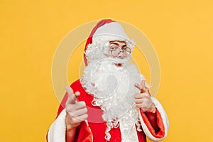 Happy Santa Claus shows his fingers to the camera and poses with a smile on his face. Christmas and New Year concept