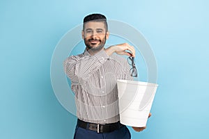 Happy satisfied businessman throwing out his optical glasses after vision treatment, looks at camera