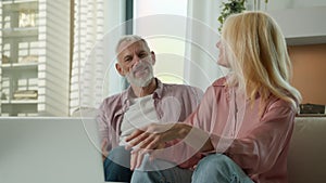 Happy satisfied Caucasian married couple grandfather grandmother man woman talking on video call using laptop at home