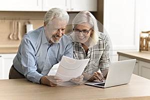 Happy satisfied senior retired couple reading legal document