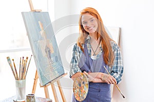 Šťastný spokojný žena maliar hotový maľovanie obrázok v umenie štúdio 