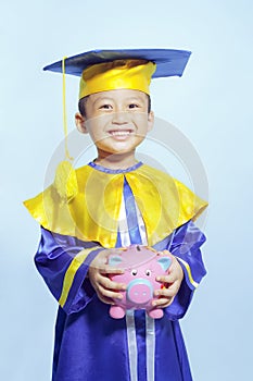 Happy scholar dressed toddler with piggybank