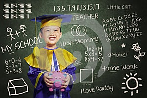 Happy scholar dressed toddler with piggybank