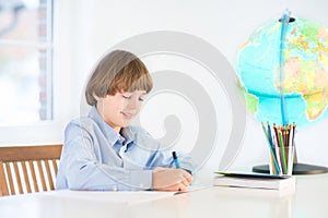 Happy school boy doing his homework