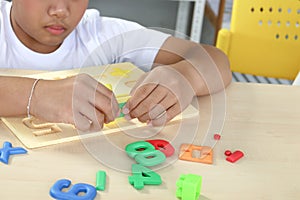 Happy school boy playing with colorful plastic toy and brick block lego on top of table, educational toys with kid hands,