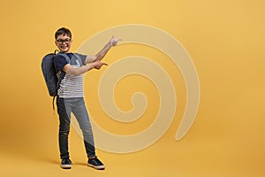 Happy school boy wearing glasses, backpack, casual outfit, copy space