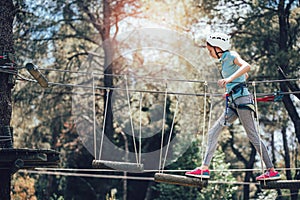 Happy school girl enjoying activity in a climbing adventure park