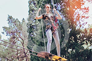 Happy school girl enjoying activity in a climbing adventure park