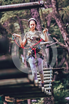 Happy school girl enjoying activity in a climbing adventure park