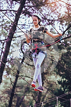 Happy school girl enjoying activity in a climbing adventure park