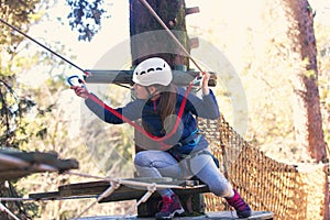 Happy school girl enjoying activity in a climbing adventure park