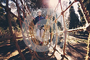 Happy school girl enjoying activity in a climbing adventure park