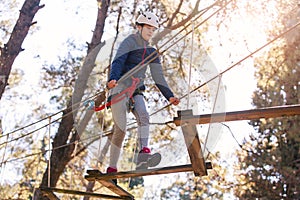 Happy school girl enjoying activity in a climbing adventure park