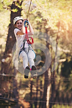 Happy school girl enjoying activity in a climbing adventure park