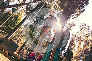 Happy school girl enjoying activity in a climbing adventure park