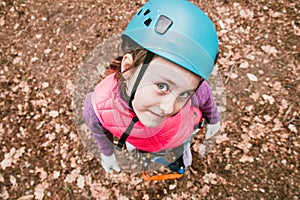 Happy school girl enjoying activity in mountain climbing adventure Park on a spring day