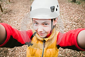 Happy school girl enjoying activity in mountain climbing adventure Park on a spring day