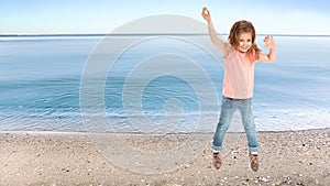 School girl jumping on beach near sea, space for text. Summer holidays