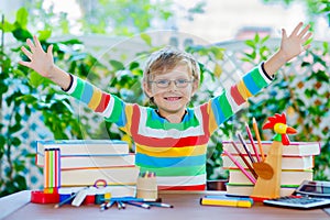 Happy school kid boy with glasses and student stuff