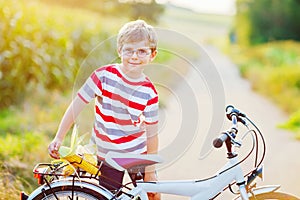 Happy school kid boy having fun with riding of bicycle. Active child making sports with bike in nature. Safety, sports