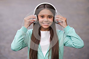 Happy school kid listen music or audio book in headphones for education and joy, childhood
