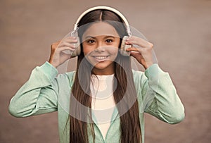 happy school kid listen music or audio book in headphones for education and joy, childhood