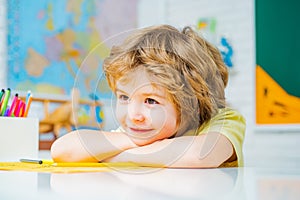 Happy school kids at lesson. Kid gets ready for school. Cute pupil with funny face schooling work. Educational process