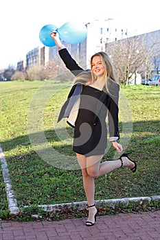 Happy school young girl with air balloons outdoor