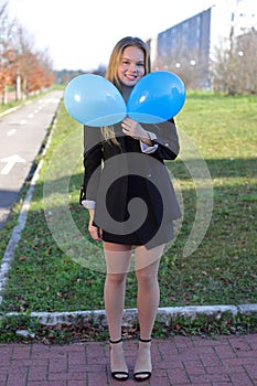 Happy school young girl with air balloons outdoor