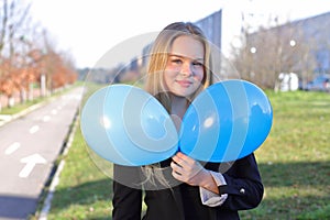 Happy school young girl with air balloons outdoor