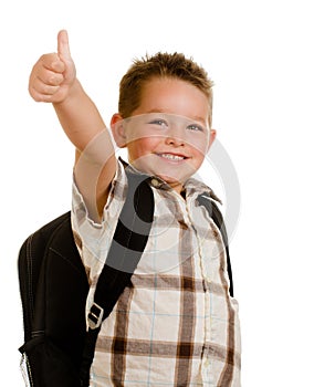 Happy schoolboy wearing backpack giving thumbs up