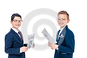 Happy schoolboys pretending to be businessmen holding newspapers Isolated On White.