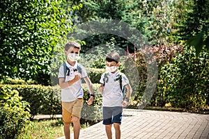 Happy schoolchildren with face masks run from the joy of returning to school during the Covid-19 quarantine photo