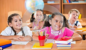 Happy schoolchildren during lesson in classroom photo