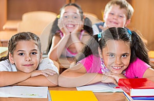 Happy schoolchildren during lesson in classroom photo