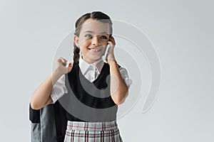 happy schoolgirl holding backpack and talking photo