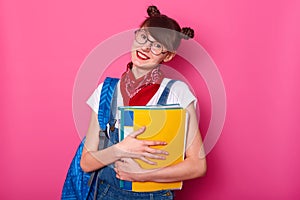 Happy schoolgirl with paper folder isolated on rosy background. Smiling girl being glad to come back school after summer holidy.