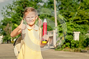 Happy schoolgirl standing on the road