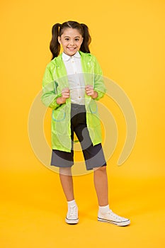 Happy schoolgirl wear raincoat. Invest in durable kids rainwear to keep children out in fresh air. Waterproof concept