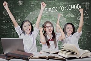 Happy schoolgirls celebrate back to school