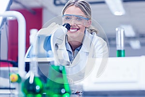 Happy science student working with microscope in the lab