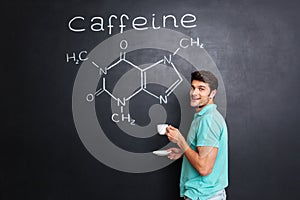 Happy scientist drinking coffee over chemical structure of caffeine molecule