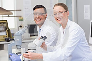 Happy scientists using microscope