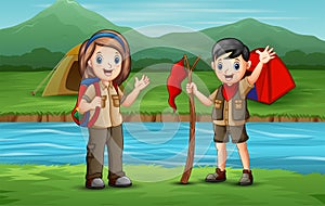 Happy scout kids camping by the river