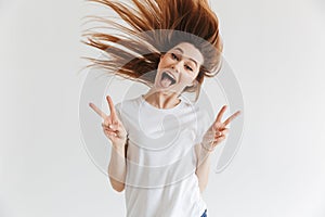 Happy screaming woman in t-shirt showing peace gestures